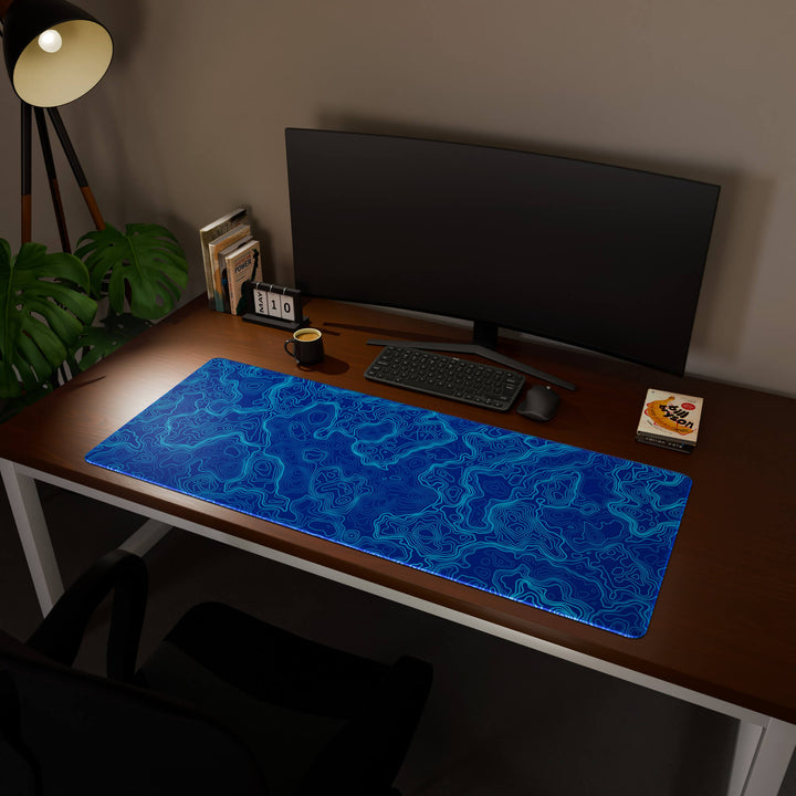 Full desktop view featuring an ultra-wide 140x57CM-55x22.4in large mouse pad / desk mat with 'Blue Topographic' design, inspired by blue minimalist topographic art. Its enormous size offers unparalleled desk protection and space, designed for large-scale workstations and immersive gaming.