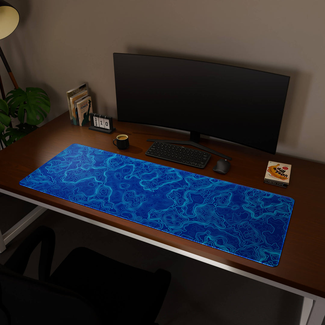 Full desktop view featuring a massive 160x57CM-63x22.4in large mouse pad / desk mat with 'Blue Topographic' design, inspired by blue minimalist topographic art. This premium, full-desk mat provides the ultimate coverage for an entire workstation, protecting the surface and unifying the space.