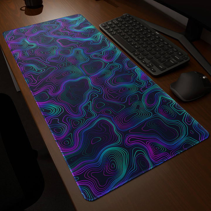 Dynamic angled perspective of a 90x40CM / 35x15.7in large mouse pad / desk mat featuring the vivid 'Neon Topographic' design, inspired by vibrant neon topographic art. Its generous dimensions offer a vast, smooth area that protects your desk while enhancing mouse glide and overall comfort.