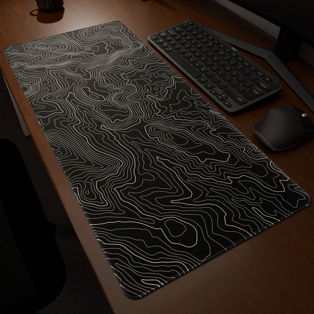 Dynamic angled perspective of a 90x40CM / 35x15.7in large mouse pad / desk mat featuring the vivid 'Classic Topographic' design, inspired by minimalist topographic line art. Its generous dimensions offer a vast, smooth area that protects your desk while enhancing mouse glide and overall comfort.