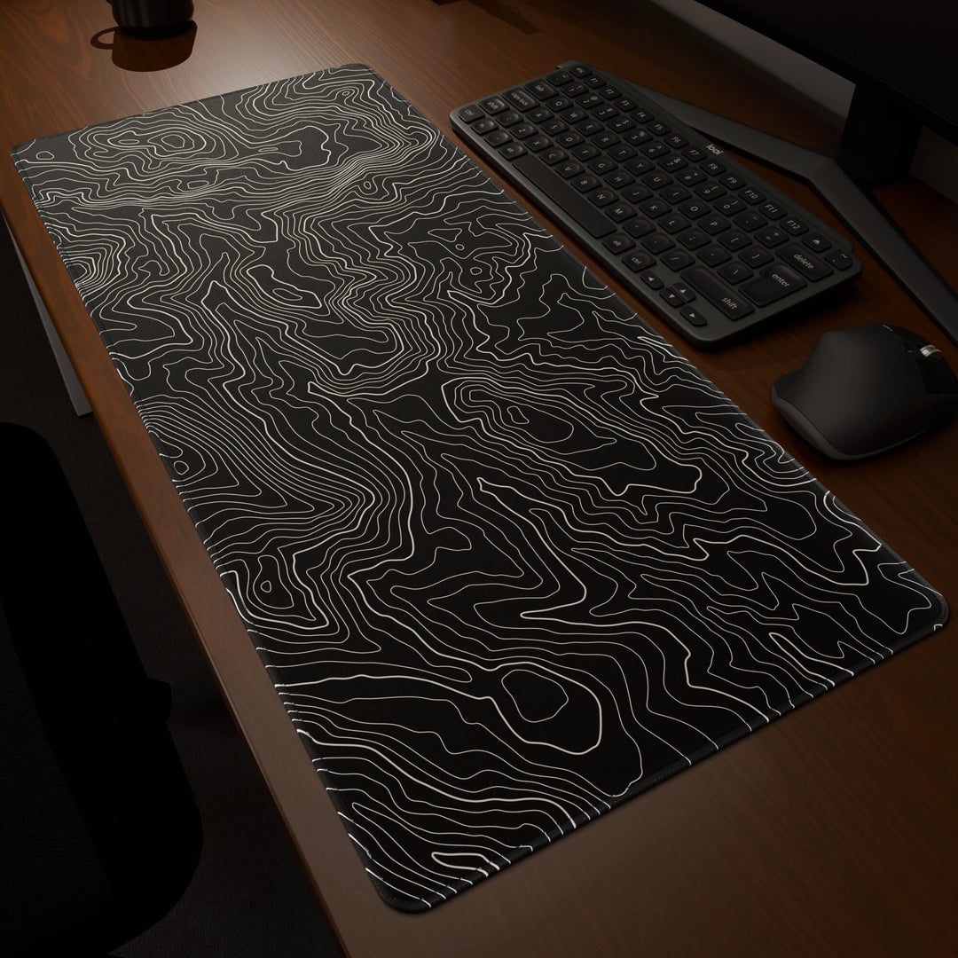 Dynamic angled perspective of a 90x40CM / 35x15.7in large mouse pad / desk mat featuring the vivid 'Classic Topographic' design, inspired by minimalist topographic line art. Its generous dimensions offer a vast, smooth area that protects your desk while enhancing mouse glide and overall comfort.