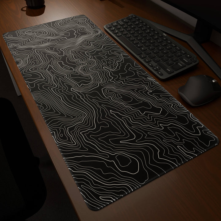 Dynamic angled perspective of a 90x40CM / 35x15.7in large mouse pad / desk mat featuring the vivid 'Classic Topographic' design, inspired by minimalist topographic line art. Its generous dimensions offer a vast, smooth area that protects your desk while enhancing mouse glide and overall comfort.