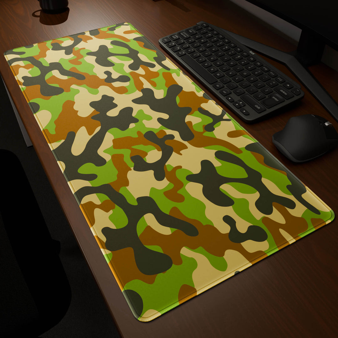 Dynamic angled perspective of a 90x40CM / 35x15.7in large mouse pad / desk mat featuring the vivid 'Woodland Camo' design, inspired by a classic woodland camouflage pattern. Its generous dimensions offer a vast, smooth area that protects your desk while enhancing mouse glide and overall comfort.
