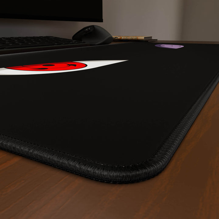 Close-up angled shot highlighting the durable stitched edges of a 90x40CM / 35x15.7in large mouse pad / desk mat with the 'Dōjutsu' design, inspired by minimalist anime ninja eyes. The reinforced stitching prevents fraying, ensuring long-lasting durability and a consistently clean aesthetic.