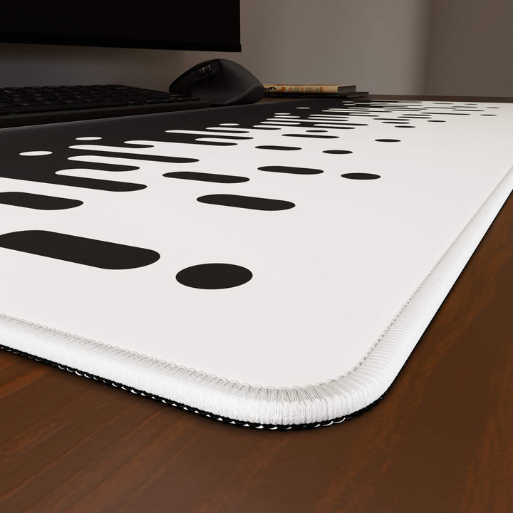 Close-up angled shot highlighting the durable stitched edges of a 90x40CM / 35x15.7in large mouse pad / desk mat with the 'Monochrome Drip' design, inspired by black and white minimalist art. The reinforced stitching prevents fraying, ensuring long-lasting durability and a consistently clean aesthetic.