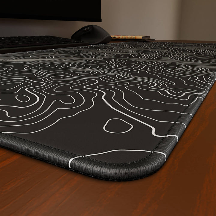 Close-up angled shot highlighting the durable stitched edges of a 90x40CM / 35x15.7in large mouse pad / desk mat with the 'Classic Topographic' design, inspired by minimalist topographic line art. The reinforced stitching prevents fraying, ensuring long-lasting durability and a consistently clean aesthetic.